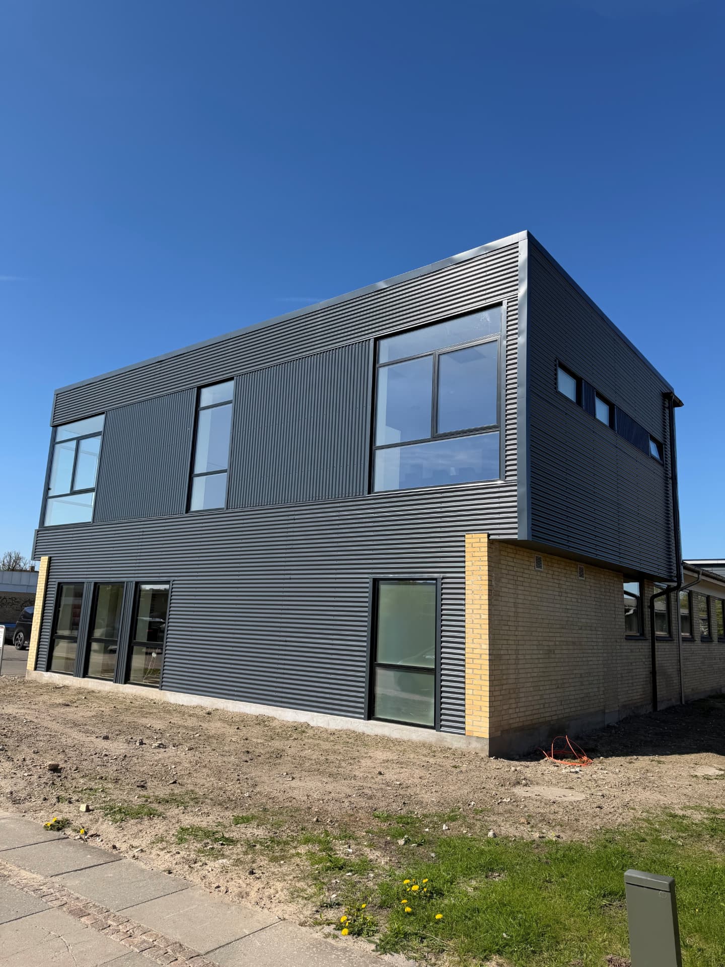 Kontor- og lagerbygningen hos Arsa Skilte set fra siden med store vinduer