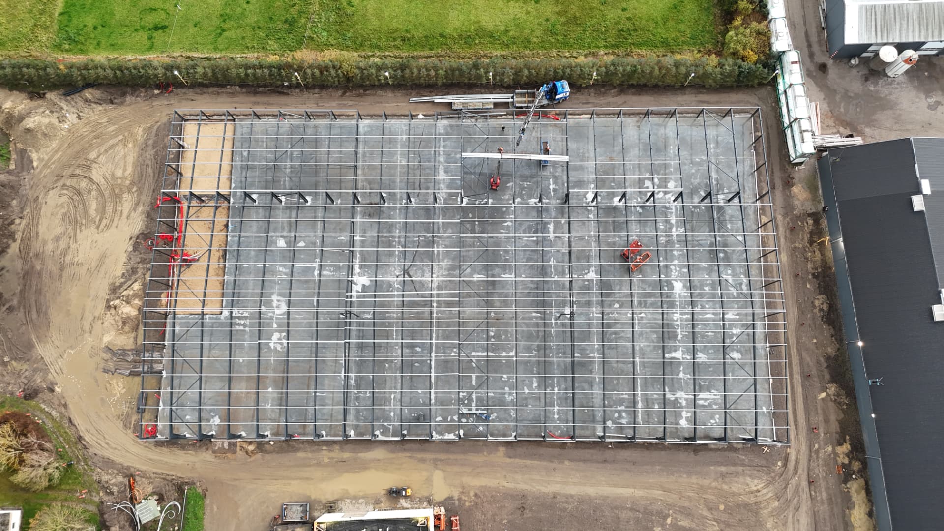 Luftfoto lige ovenfra af hele byggefeltet med stålbjælkerne til hallen i Løkken