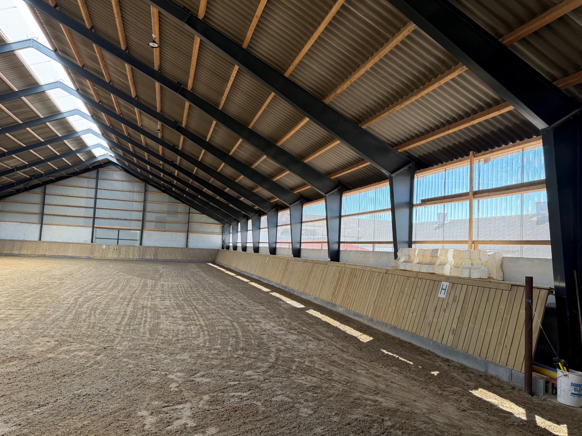 Indvendigt foto af ridehallen i Havbro fra hjørnet med banemarkeringer