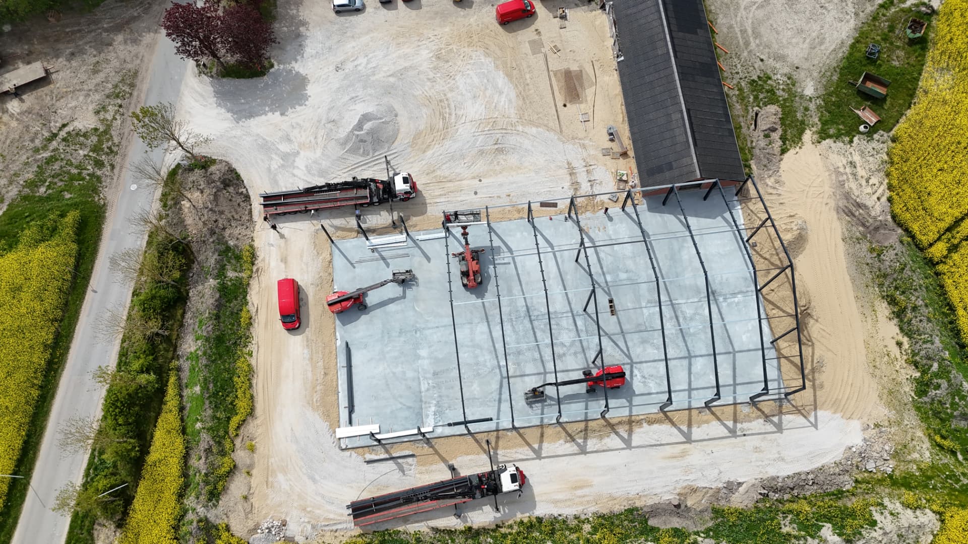 Dronefoto lige ned over stålskelettet på kartoffelhuset i Aggersund med entreprenørmaskiner